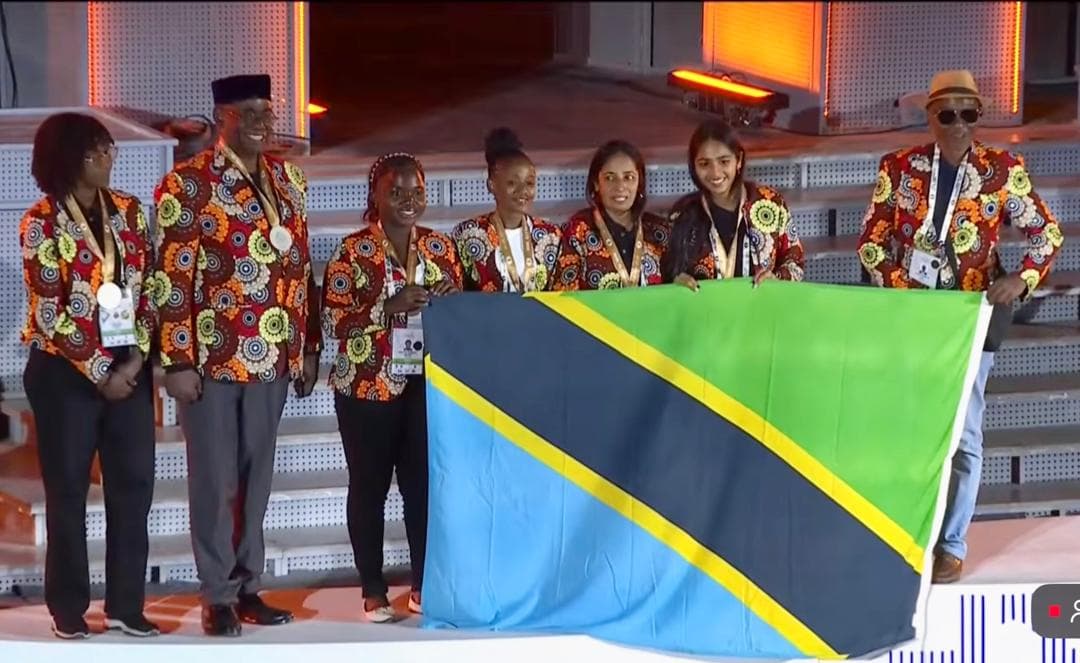 Tanzania’s delegation celebrates with medals and the national flag.